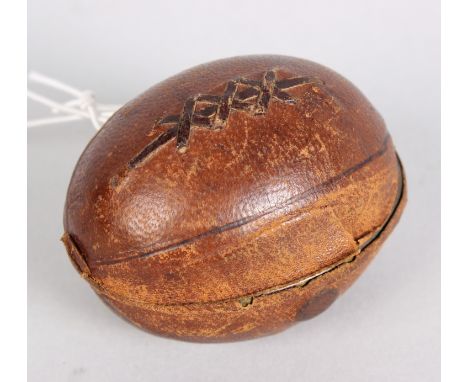 A Victorian novelty travelling inkwell, shaped as an American football covered in dark tan leather, opening to reveal the gil