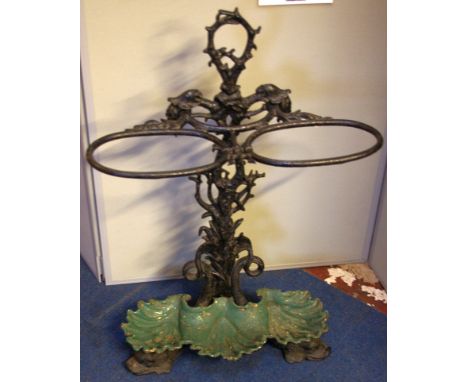 A Victorian cast iron stick stand with two oval stick supports and foliate stem on shell base with dolphin feet registration 