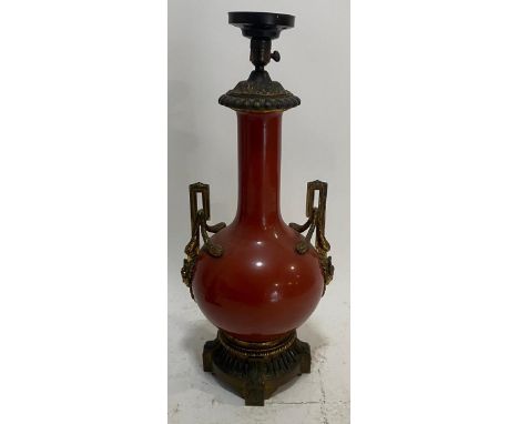 A large 19th Century Chinese monochrome red glazed bottle vase. Cylindrical neck with bulbous body raised on gilt metal stand