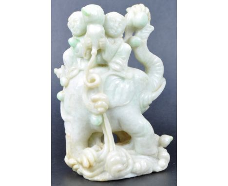 A 19th Century Chinese carved jade figurine depicting an elephant with child seated on back. The elephant raised on scrolled 