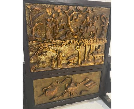 A 19th Century Chinese hand carved gilded fire screen. Ebonised black border &amp; frame with carved sacred / precious object
