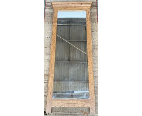 A light oak framed long mirror with pediment top