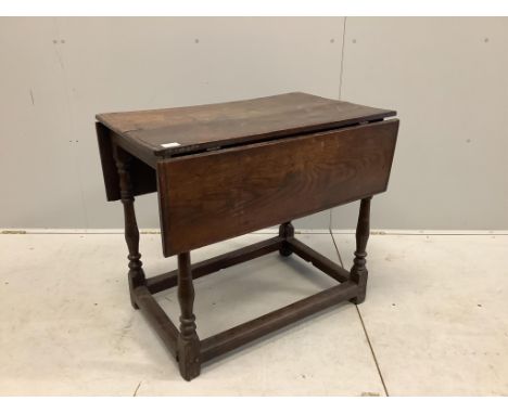 A 17th century rectangular oak drop leaf table on turned legs stretcher rail, label with '165' on the underside and a small w