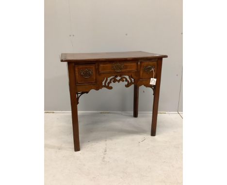 A mid 18th century walnut lowboy quarter veneered with a rectangular top above three drawers and a pierced apron on chamfered