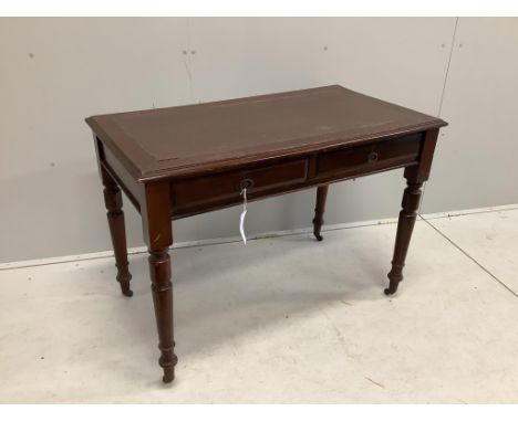 An early 20th century mahogany writing table with two frieze drawers with brass ring handles on turned legs and castors, widt
