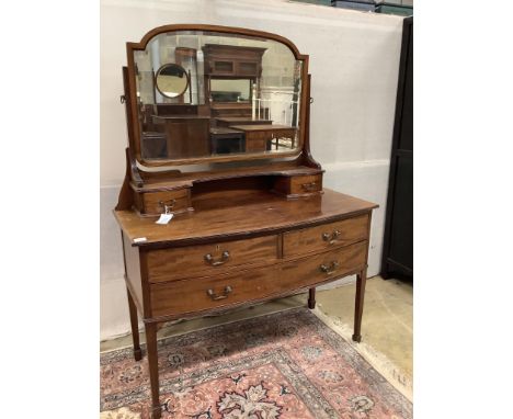 An early 20th century mahogany bowfront dressing table, fitted two short and one long drawer with brass loop handles and squa