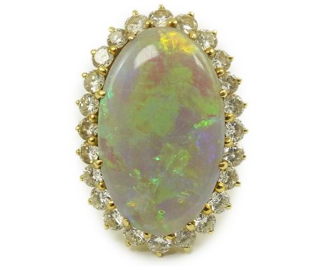 An 18ct  gold, white opal and diamond set oval cluster dress ring, the cabochon opal measuring approximately 22mm by 14.5mm, 