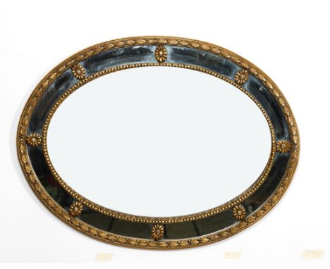 A REGENCY STYLE GOLD PAINTED OVAL MARGINAL WALL MIRROR100cm wide; 75cm highProvenanceThe collection of the lateCountess Bunny