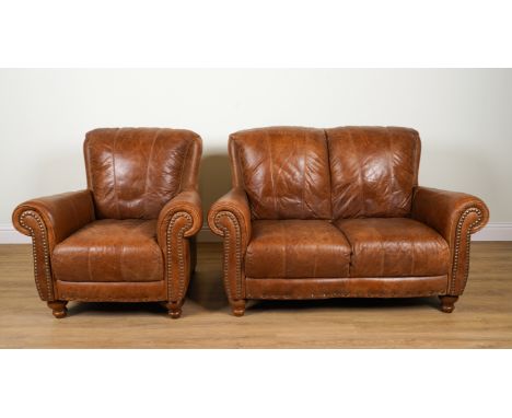 A TAN LEATHER TWO SEAT SOFA (2)With studded upholstery 143cm wide; 97cm high and a matching armchair 90cm wide; 97cm high