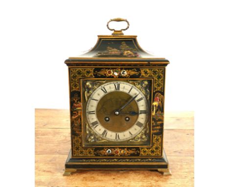 A BLACK LACQUERED JAPANNED MANTEL CLOCK20th Century
The brass dial with silvered chapter ring and applied angel mask spandrel