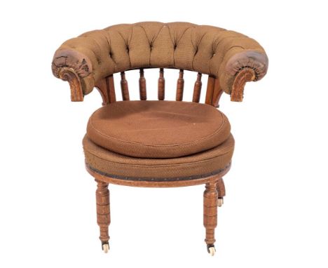 A Regency oak and button upholstered 'cockfighting' chair, circa 1815,: the padded tub back on turned supports, above a circu