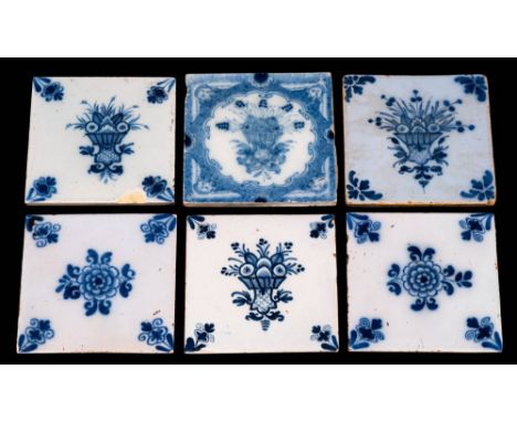 A group of six 18th century English blue and white delftware tiles: floral subjects comprising a set of three painted with a 