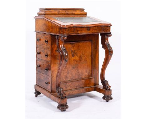 A Victorian walnut Davenport, circa 1870,: the raised stationery compartment with hinged cover and ogee moulded front and sid