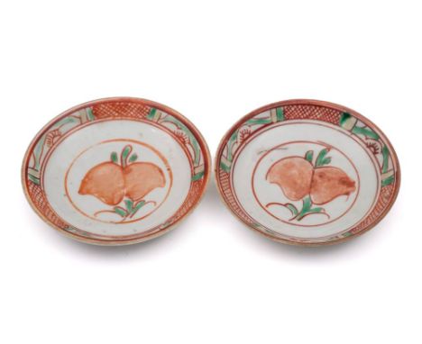 A pair of Chinese swatow saucers: each enamelled in red, green and yellow with a peach spray, 17th century, 11cm.