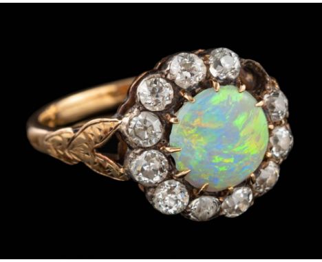 An opal and diamond ring,: the circular cut opal claw set within a surround of old brilliant cut diamonds, stamped 18ct, ring
