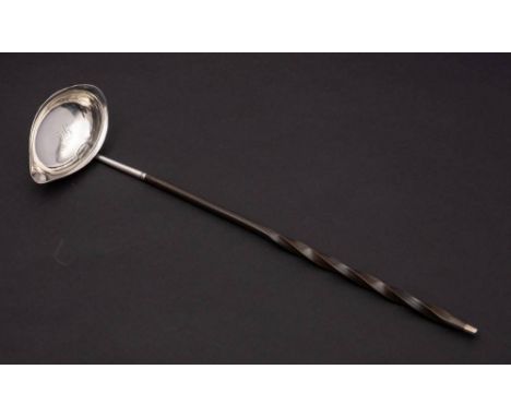 A late Georgian silver toddy ladle, unmarked: the oval bowl with monogram, mounted on a baleen spiral twist handle, 36cm long
