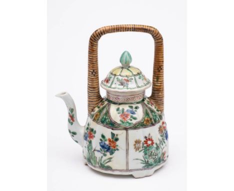 A Chinese famille verte wine pot and cover: with overhead 'bamboo' handle, painted with panels of flowering shrubs and rockwo