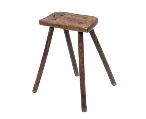 A primitive Victorian oak stool, second half 19th century,: the shaped seat stamped W &amp; H to the underside, on four turne