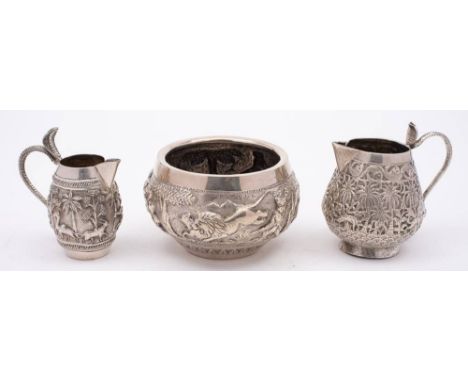 An Indian silver sugar basin: of circular form with embossed hunting scenes, 10.5cm diameter, together with two silver cream 