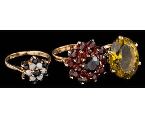 A 9 carat gold garnet cluster ring,: set with circular cut garnets, stamped 375, ring size O; and two further gem set rings.