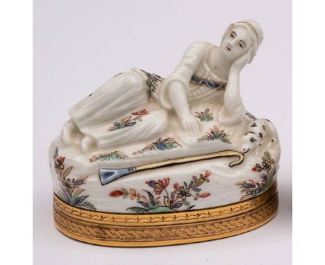 A St.Cloud gilt-metal mounted snuff box and cover: in the form of a reclining shepherdess, her head resting on her left hand,