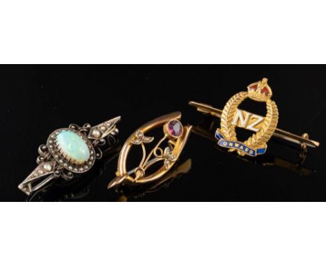 An opal and seed pearl brooch,: the oval cabochon opal within a surround of seed pearls, 4cm wide; and two further brooches.