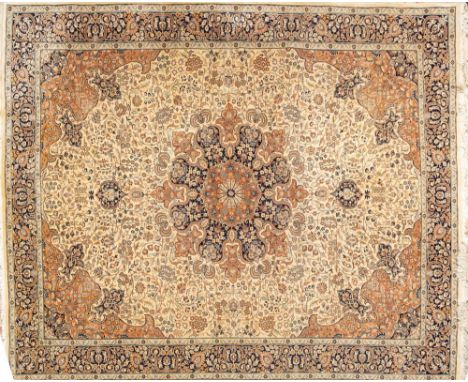 An Indo Persian Carpet:, the ivory field with a central indigo and light brown flowerhead medallion and similar spandrels, al