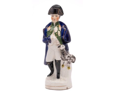 A Staffordshire pottery portrait figure of Napoleon: modelled standing in military uniform with an imperial eagle to one side