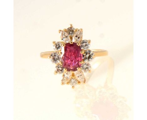 A ruby and diamond cluster ring, the oval mixed cut ruby 7.5x5.7mm, claw set and surrounded by four marquise cut diamonds and