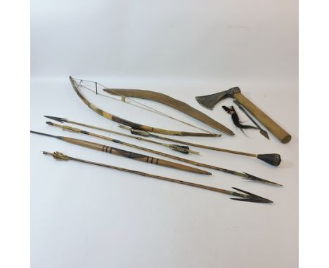 A collection of ethnic items, to include bows and arrows, an antique axe etc