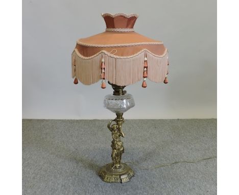 A 19th century gilt metal, figural oil lamp, with a cut glass reservoir and pink shade, 88cm tall