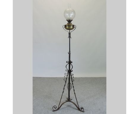 A cast iron and brass standard oil lamp, with an etched glass shade, 176cm tall