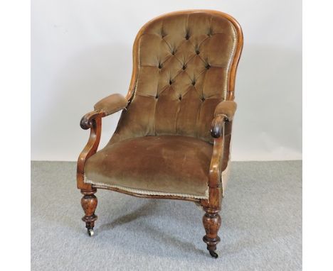 A Victorian brown upholstered show frame button back armchair