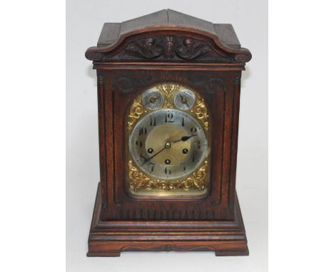 A Junghans oak cased mantel clock with brass face having chime/silent and speed dials, key and pendulum, height 41cm.  