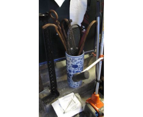 Modern blue and white china stick stand with various sticks, umbrella etc, together with a vintage plunger and a metal fire f