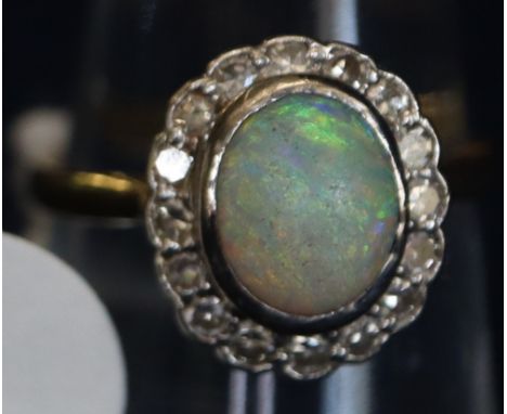 Opal and diamond oval cluster ring on yellow metal band. (B.P. 24% incl. VAT) CONDITION REPORT: Ring size K/L. Weighing appro