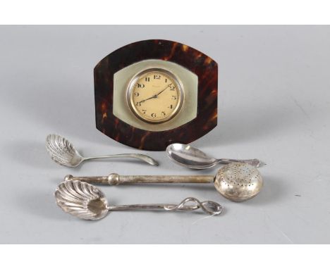 A tortoise shell and silver plated eight-day strut clock, a silver plated tea infuser and three silver plated spoons 