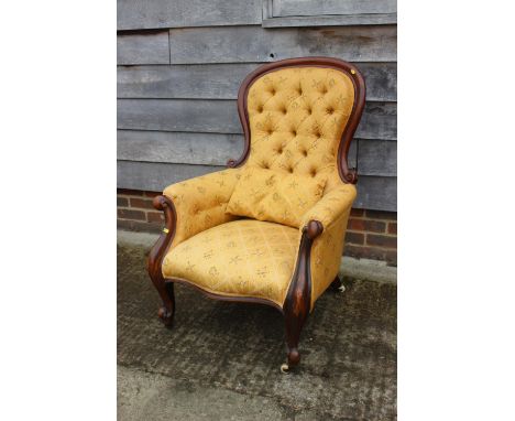 A Victorian mahogany showframe button back armchair, upholstered in a gold floral fabric, and a matching Victorian loop back 