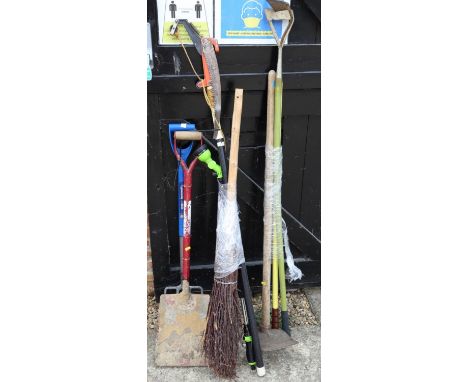 A besom broom, a mattock and other garden tools 