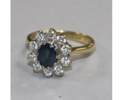 A modern 18ct gold, sapphire and diamond oval cluster ring, size K.