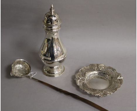 A repousse white metal toddy ladle with baleen handle, a large silver sugar caster and a repousse silver bonbon dish.