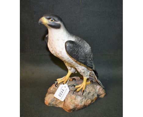 A large Royal Crown Derby model of a Falcon perched on a rocky outcrop, in naturalistic shades, decorated by K Woods, signed 