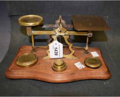 A set of early 20th century postal scales and weights, mahogany base 