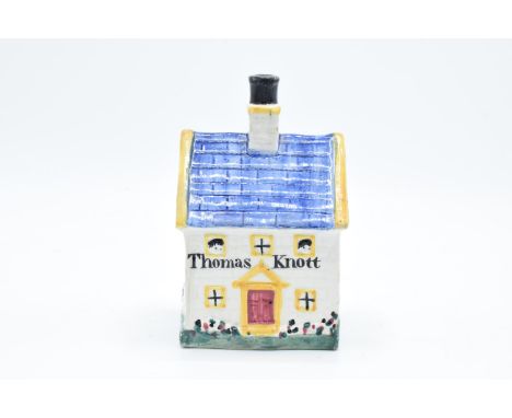 A mid 19th century Pratt Ware cottage money box (believed to be Yorkshire) in the form of a house with chimney with the title