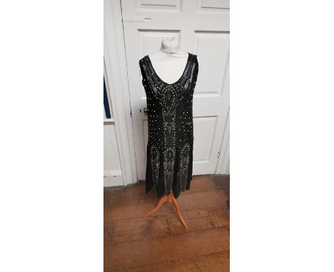 A black beaded Art Deco 1920s dress, this iconic dress is embellished in silver and black bugle beads, paste stone beads (som