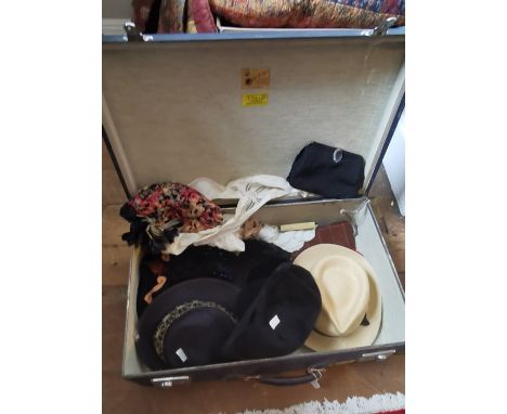 A 1940s suitcase with the initials R. F. H. containing a collection of accessories to include a 1920s belt, a hat with a band