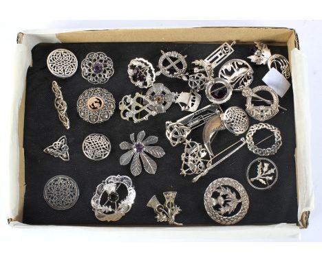 A collection of Scottish silver and white metal brooches. In a variety of designs, including thistles, a luckenbooth, Celtic 