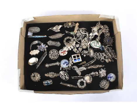 A collection of silver and white metal brooches and pins. Of a variety of designs, some with pierced, ceramic, enamel and mou