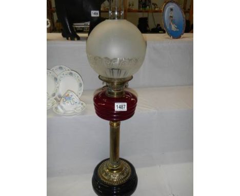 A Victorian oil lamp with ruby glass font on brass base and with original etched shade, COLLECT ONLY.