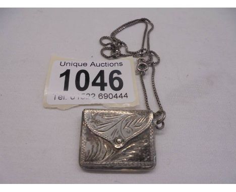 A vintage silver purse on a white metal chain.